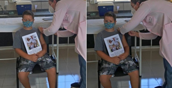 Menino de 7 anos toma vacina e faz homenagem aos avós que morreram de Covid: