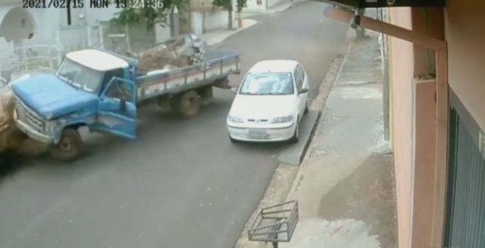 Caminhão sem motorista desce rua desgovernado e bate em poste e caminhonete