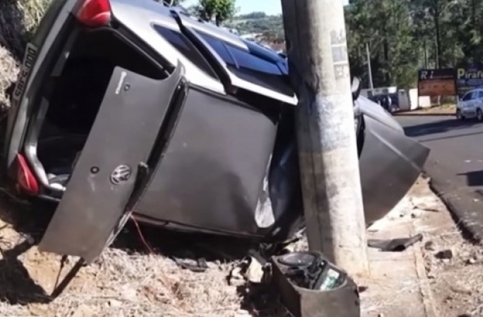 Carro fica preso entre poste e barranco após capotar em Piraju