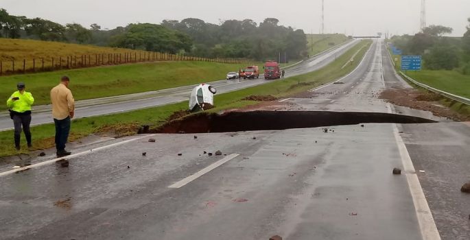 Equipes fazem buscas por caminhão que sumiu ao cair em cratera aberta em rodovia